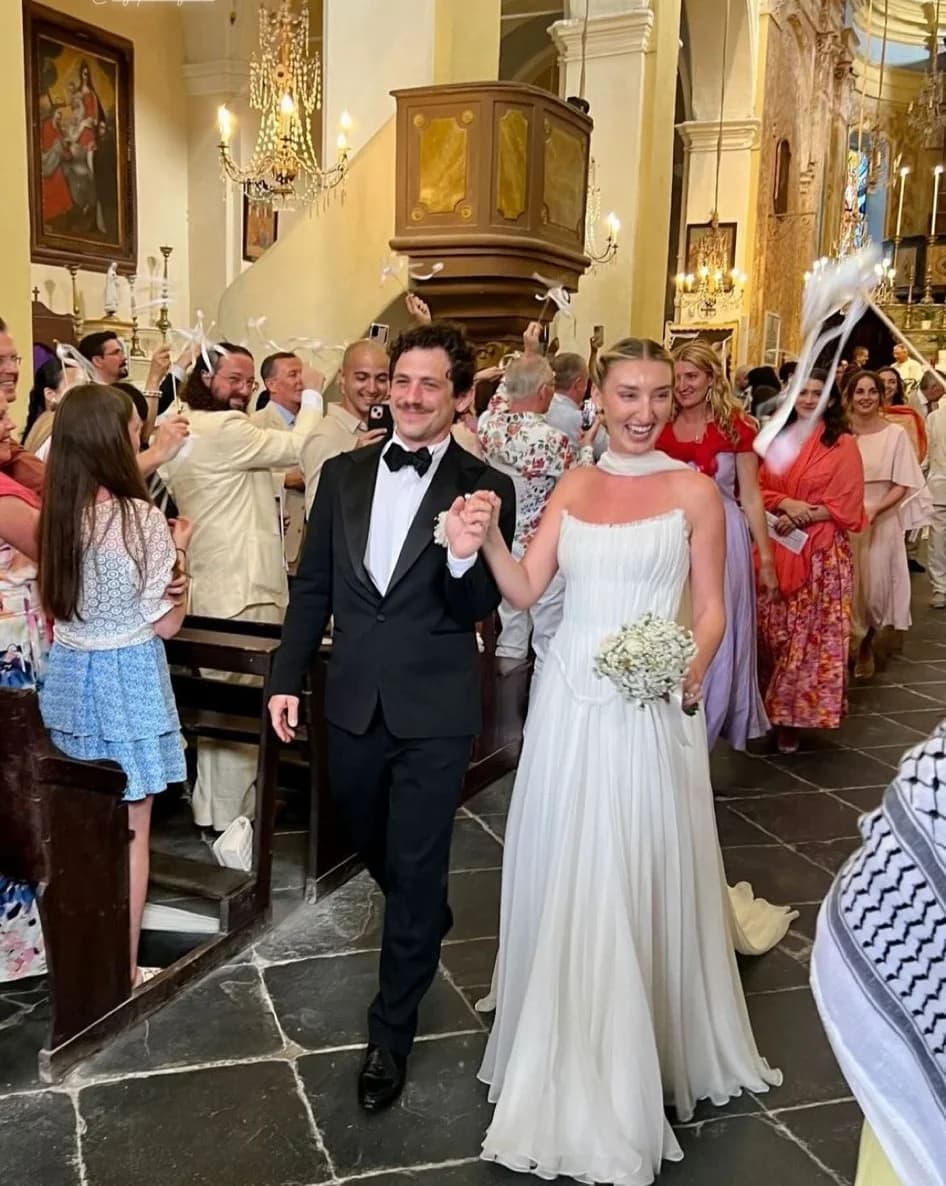 Bride and groom walking through a church with guests.