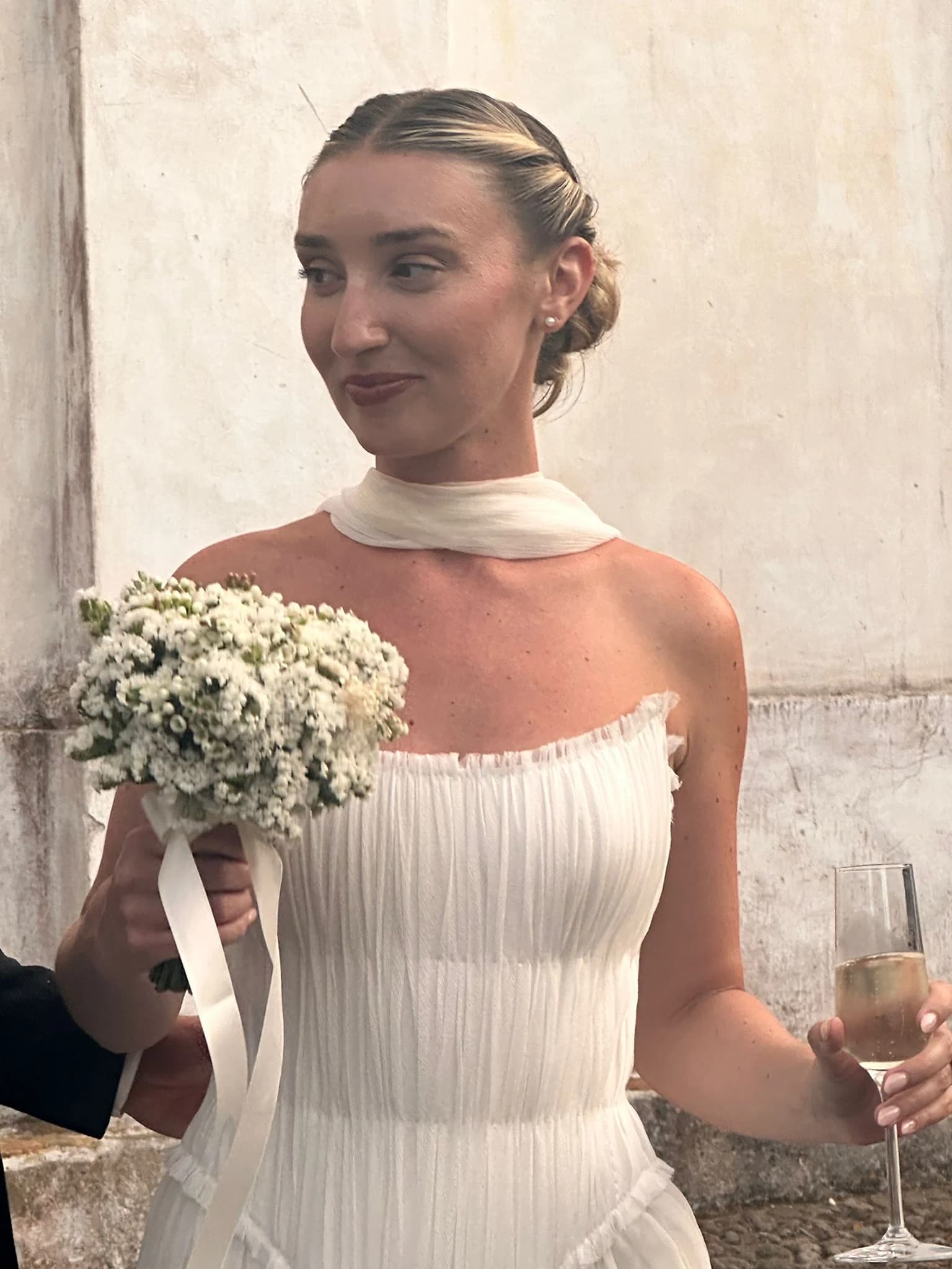 Bride holding a bouquet at a wedding reception.
