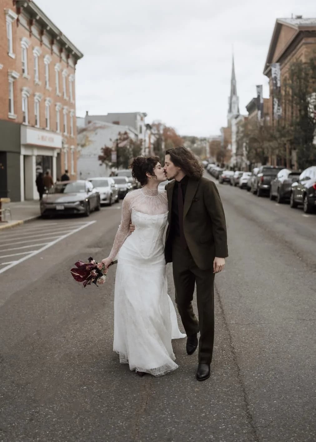 Bride and groom kissing in a city street.