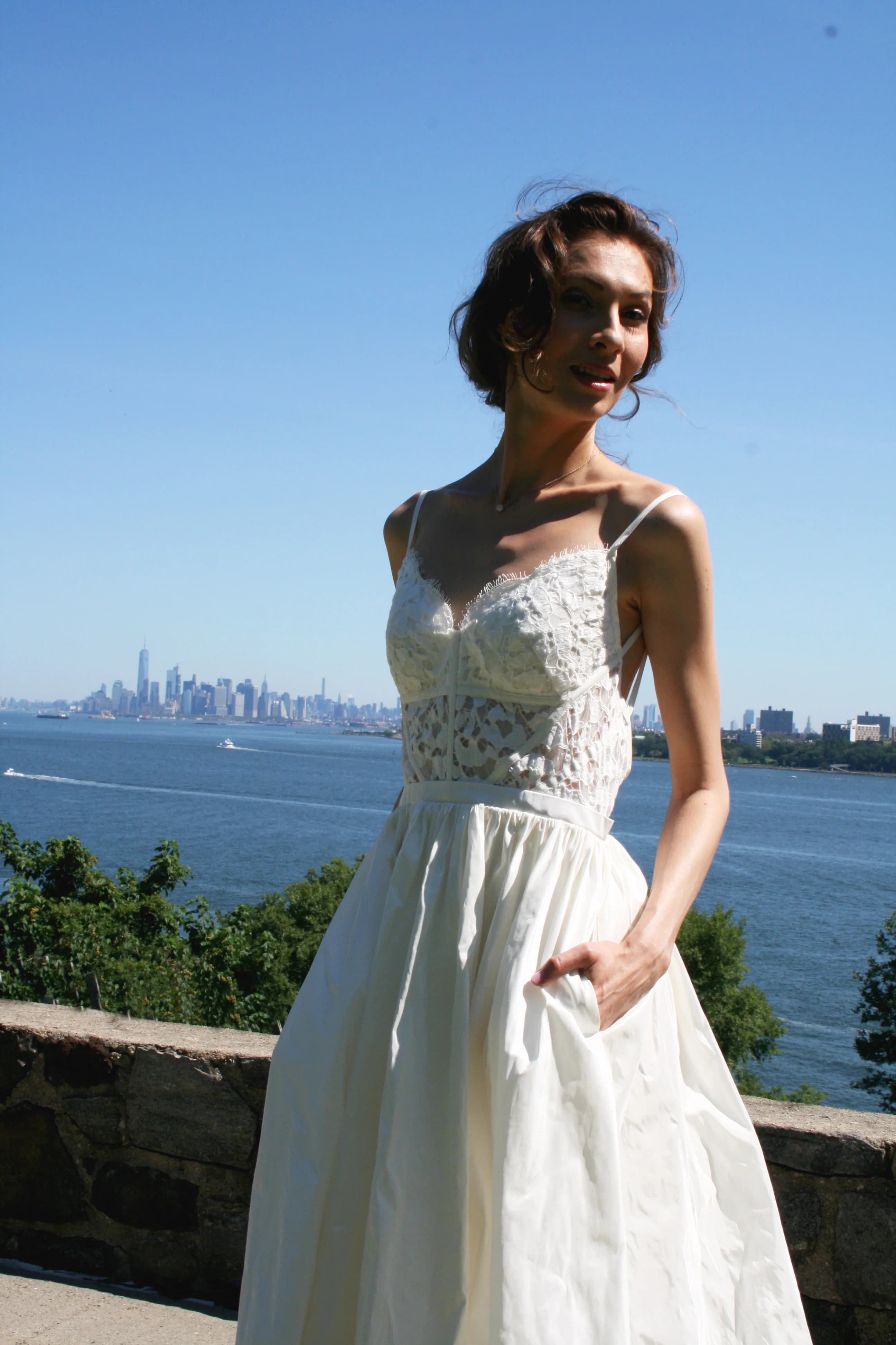 Close view of a lace bodice with the city skyline behind her.