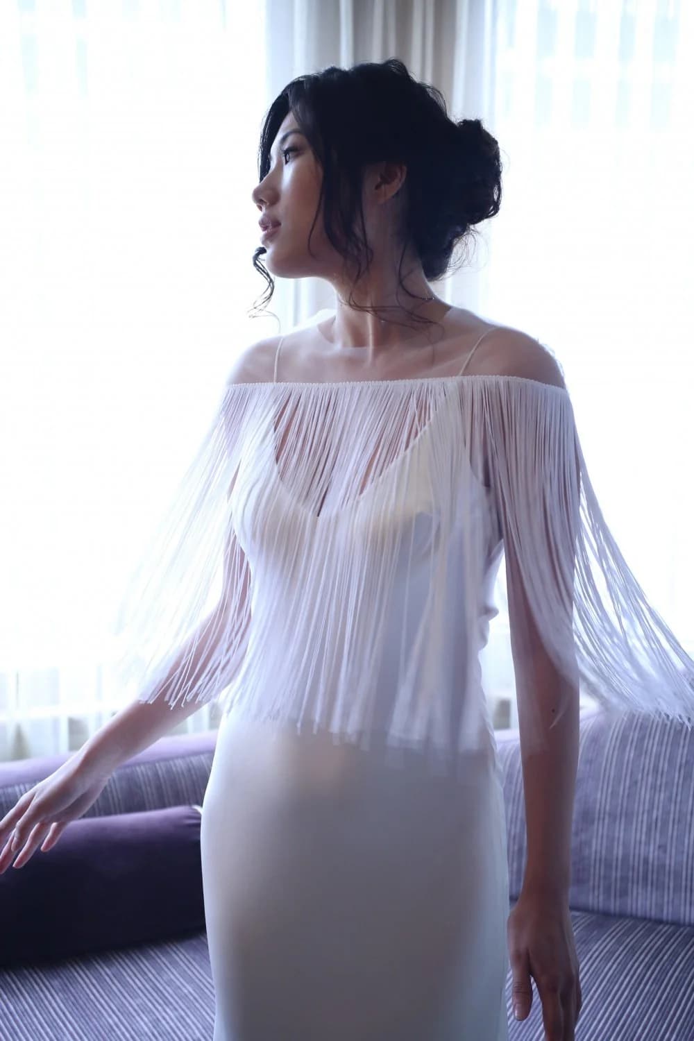 Close view of a bride in a fringed cape.