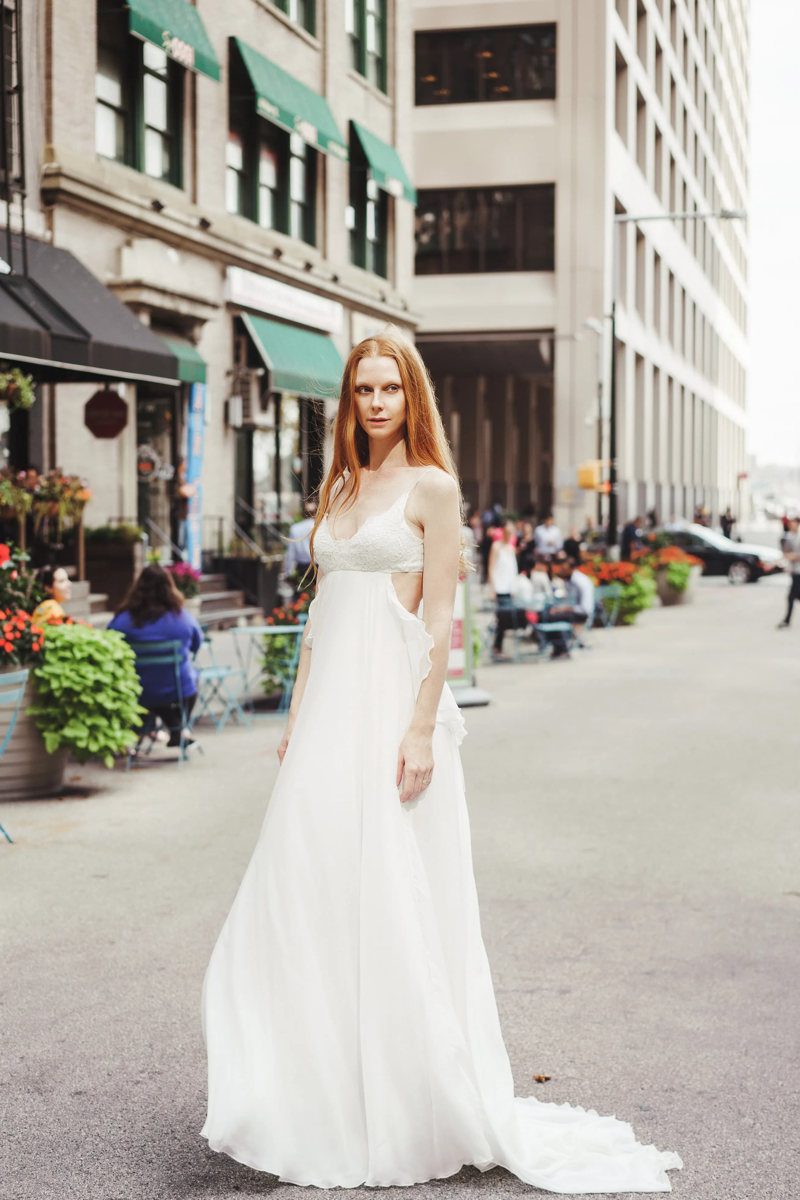 Bride wearing a white gown on a city street.