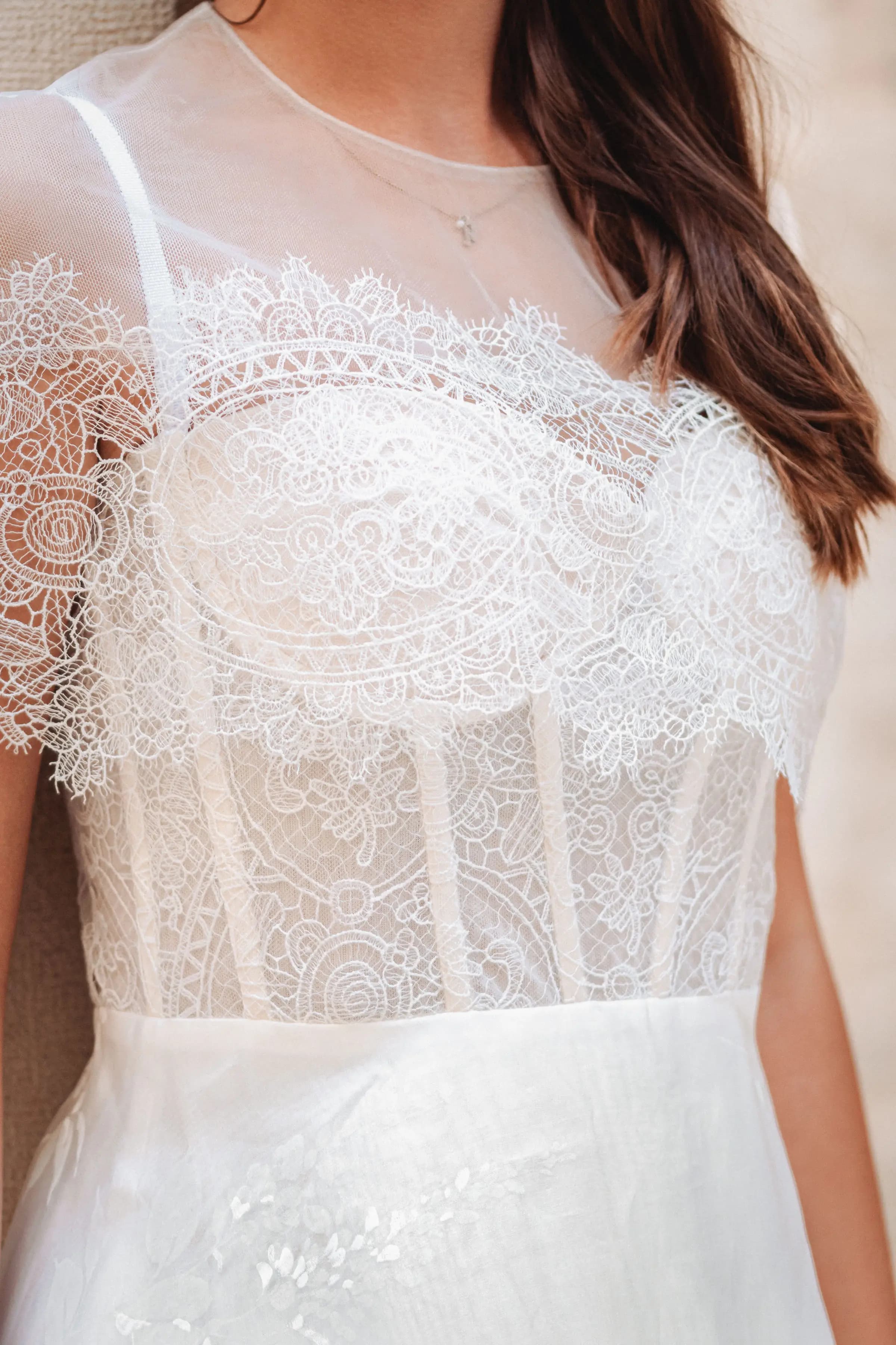 Close view of a sheer lace bodice with floral embroidery.