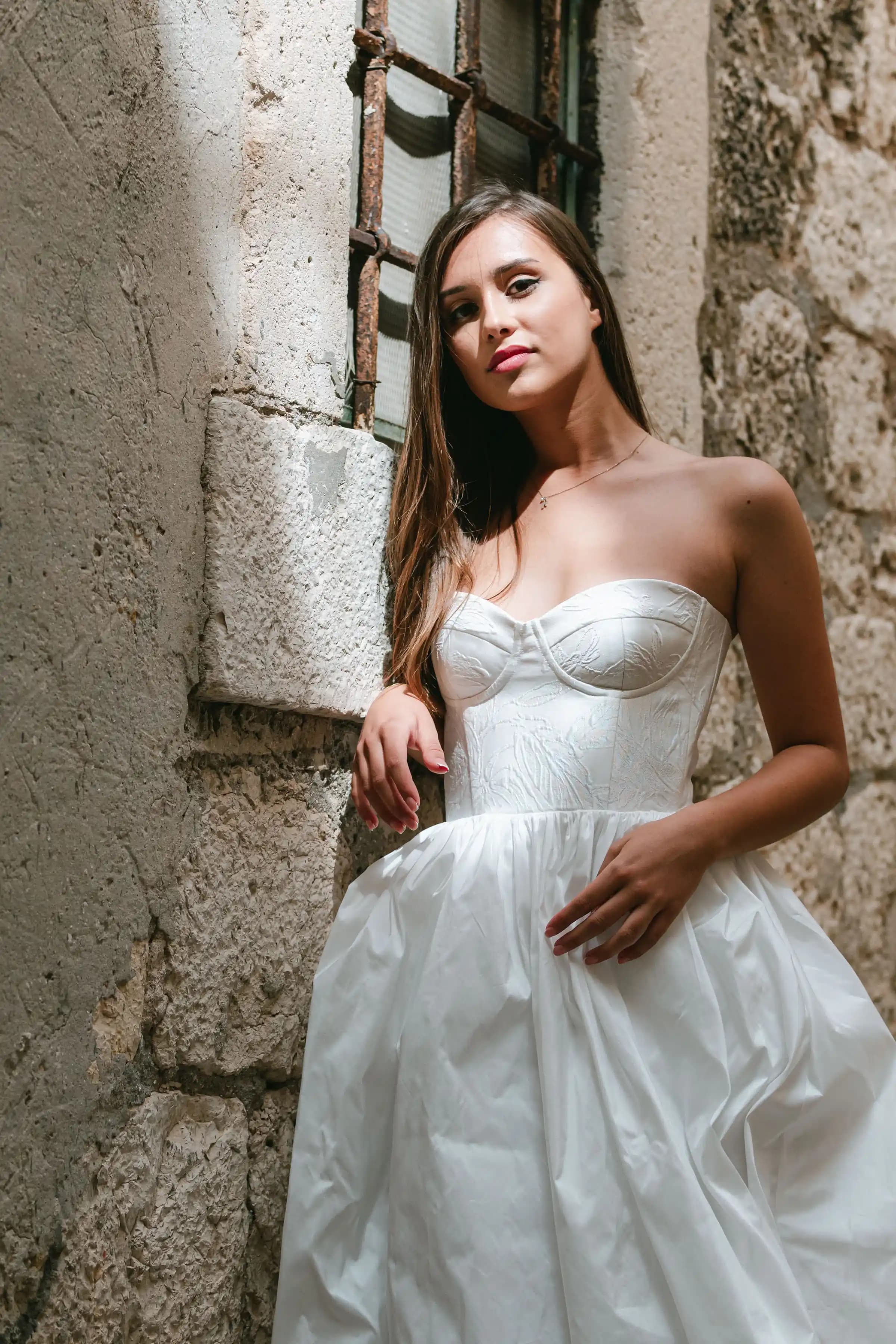 Close portrait of a bride in a strapless white gown.