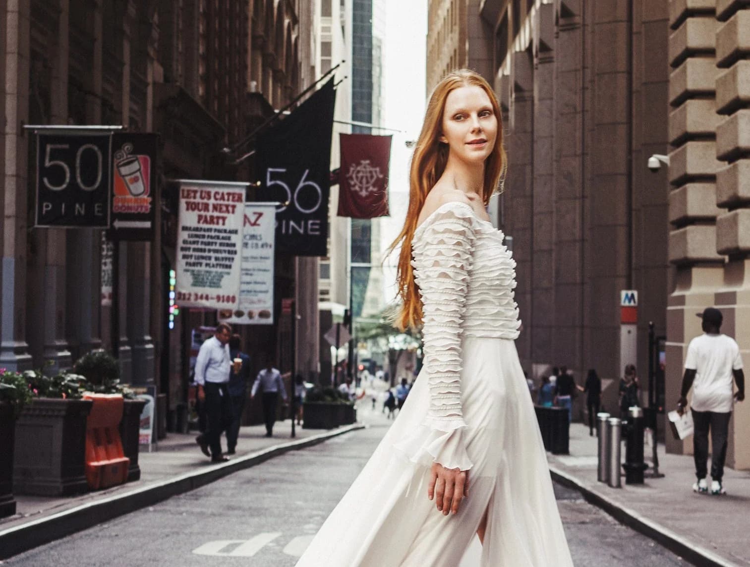 A bride in a Nazarela gown walking through a city street